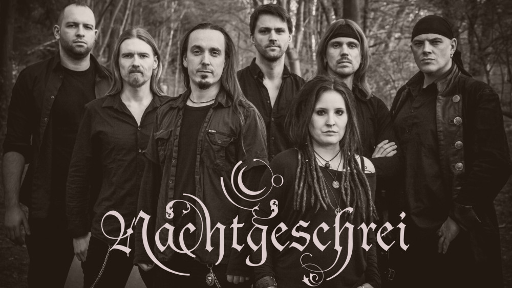 Auf dem Bild sieht man sieben Personen. Alle sind komplett in schwarz gekleidet und schauen ernst in die Kamera. Im Hintergrund ist ein Wald zu sehen. Unten in der Mitte des Bildes ist das Logo der Band abgebildet.